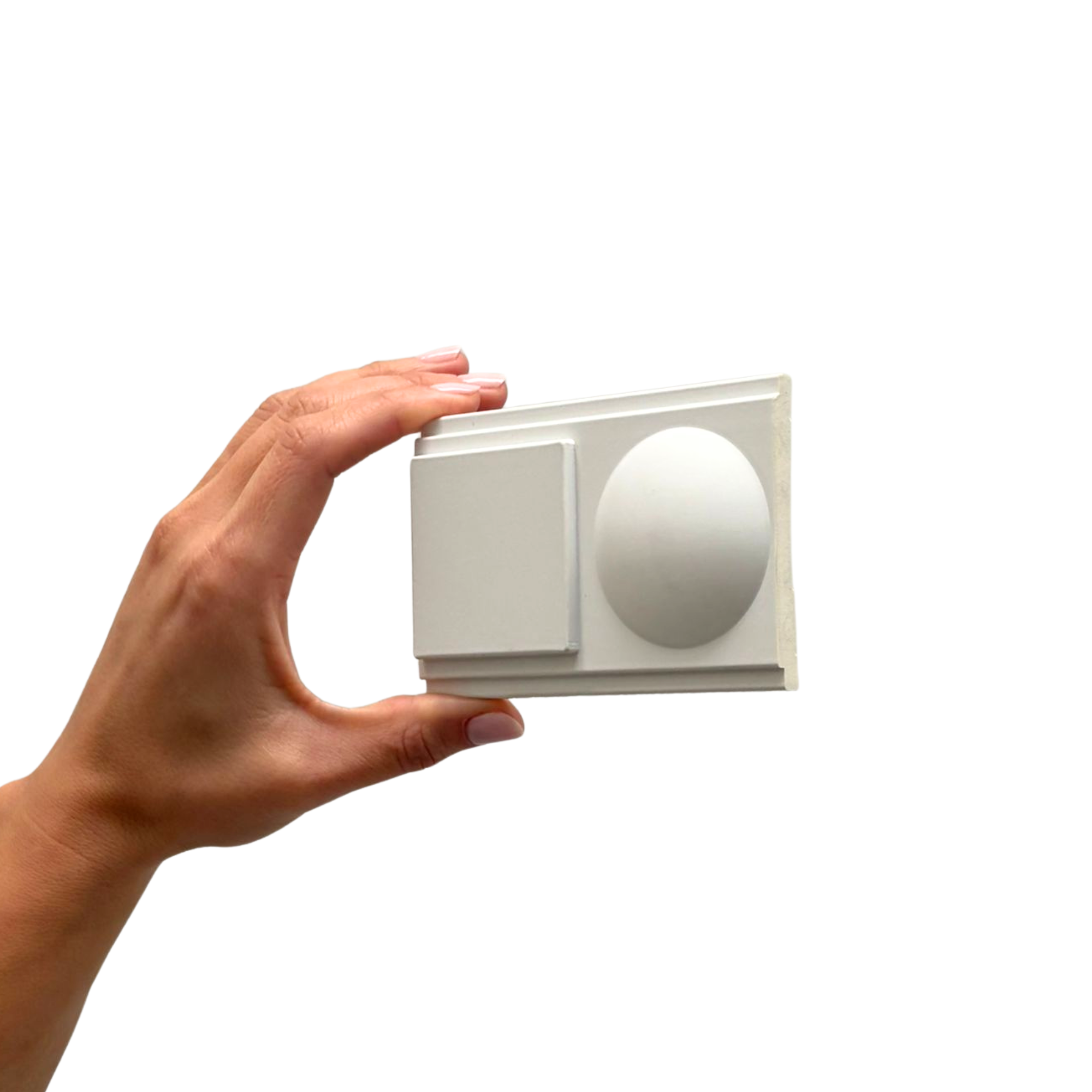 Hand holding a gray rectangular control with a large circular knob on a white background.